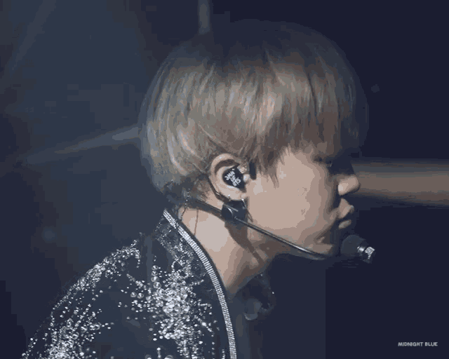 a close up of a person wearing a microphone and earbuds with the words midnight blue on the bottom
