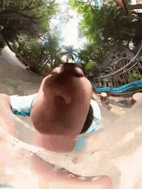 a person is swimming in a pool and looking at the camera