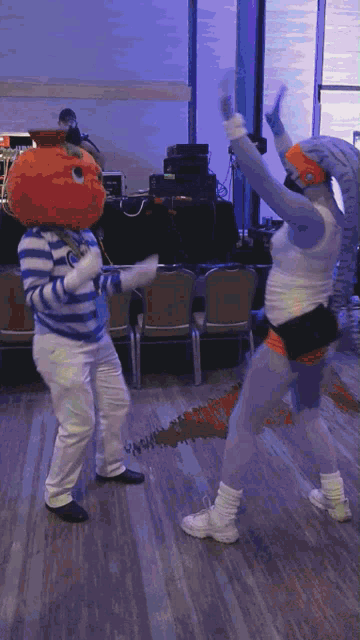 two people in costumes are dancing in a room
