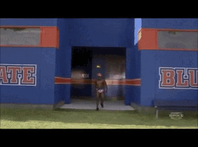 a man walking into a blue building with the word blu on it