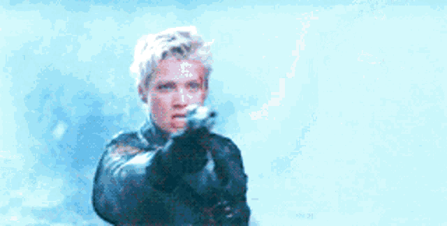 a woman is pointing a gun at the camera in a blurry photo