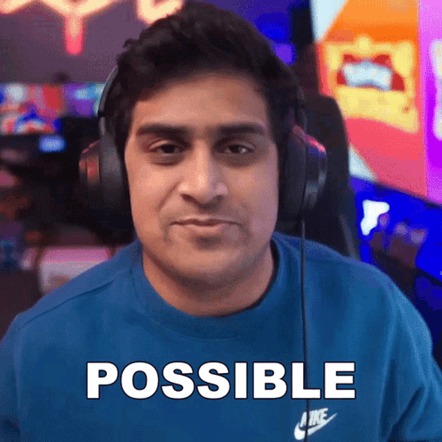 a man wearing headphones and a blue shirt with the word possible written on it