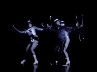 a man and a woman are dancing on a stage with their sticks .