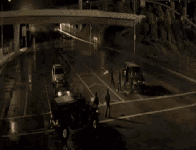 a man is standing in front of a black car with smoke coming out of the hood .