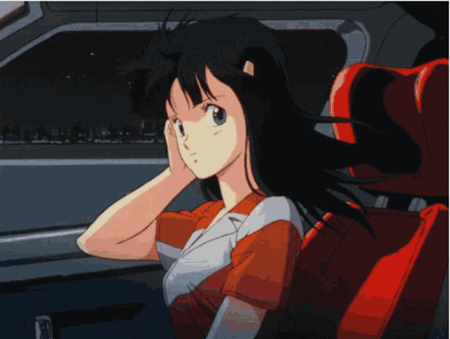 a girl with long black hair is sitting in a red car seat