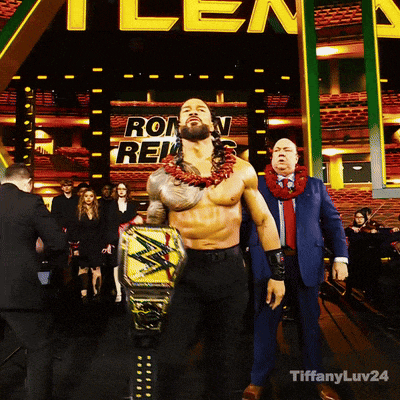 a man holding a wrestling belt stands in front of a sign that says ron reis