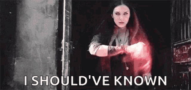 scarlet witch is holding a red light in her hand and saying `` i should 've known '' .