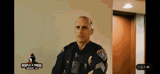 a police officer stands in front of a sign that says people u preds on it