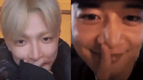 a man is covering his mouth with his hand and another man is making a funny face .