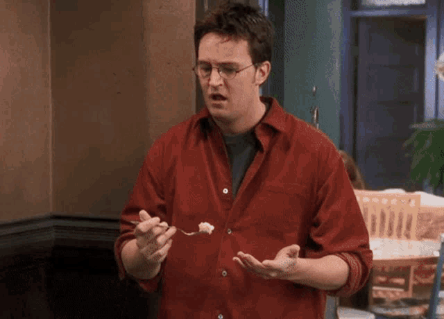 a man in a red shirt is talking to a woman in a green shirt