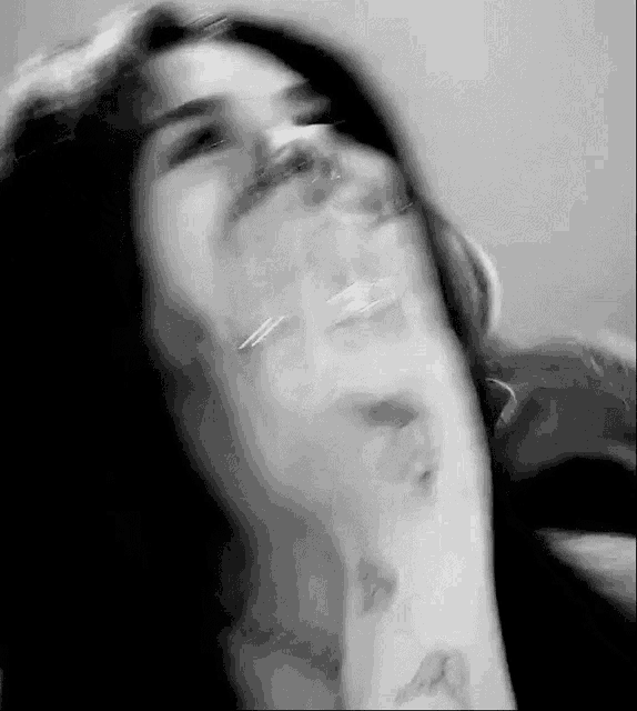 a black and white photo of a woman 's face with her mouth open