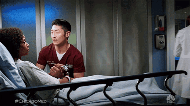 a man holding a woman 's hand in a hospital bed with #chicagomed on the bottom right