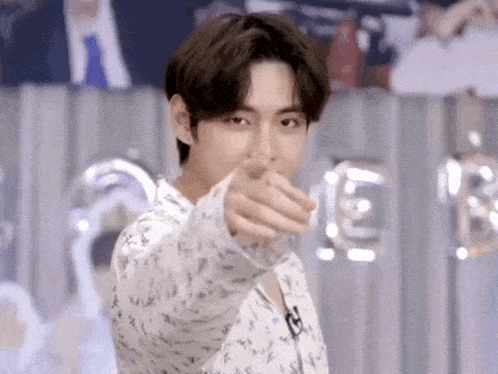 a young man is pointing his finger at the camera .