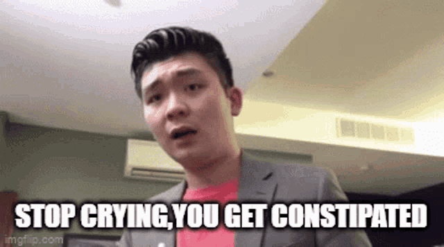 a man in a suit and red shirt is making a funny face and saying `` stop crying , you get constipated ''