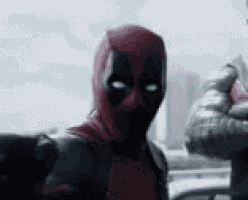 a close up of a man in a deadpool costume taking a selfie with a camera .