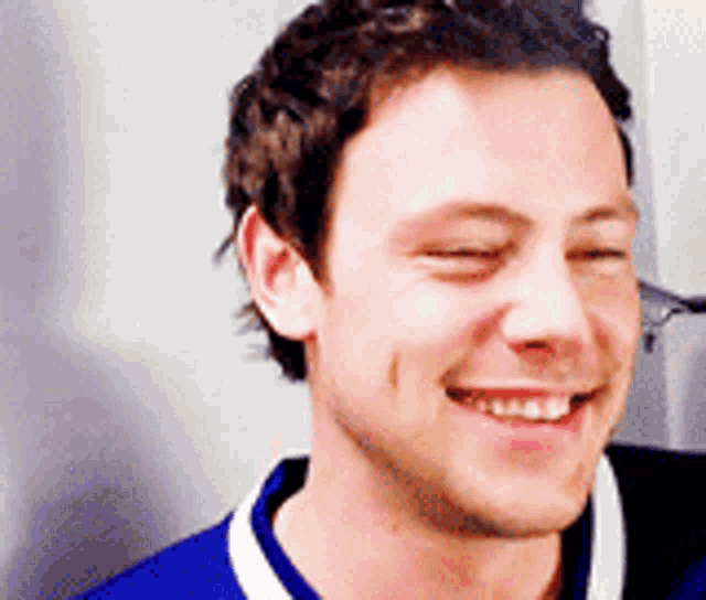 a close up of a man 's face with his eyes closed smiling