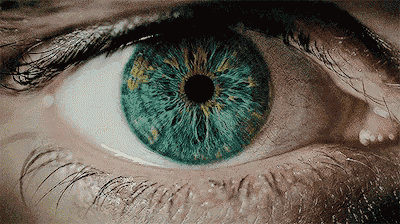 a close up of a person 's blue eye with a tear coming out of it