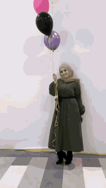a woman in a green dress is holding balloons in her hand