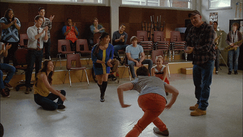 a group of people are dancing in a room with a sign that says just play on it