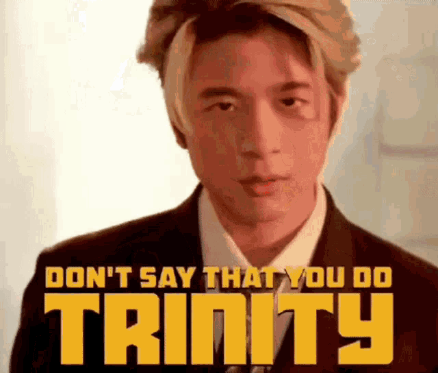 a man in a suit and tie is standing in front of a sign that says don 't say that you do trinity .
