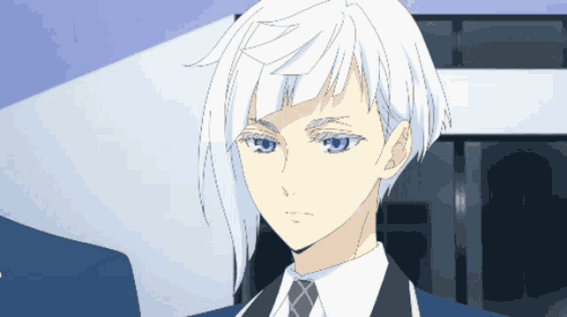 a man with white hair and blue eyes is wearing a suit