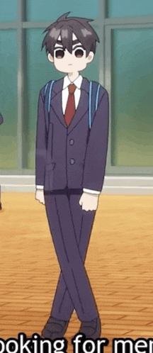 a boy in a suit and tie is standing next to a window