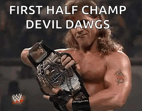 a man holding a wrestling belt with the words first half champ devil dawgs on the bottom