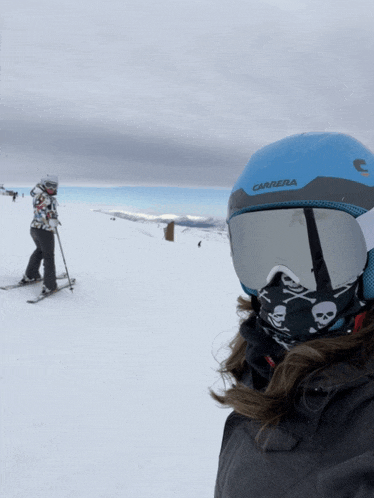 a person wearing a carrera helmet and goggles stands in the snow
