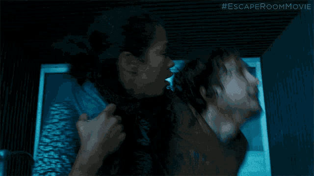 a woman is carrying a man in a dark room with the escaperoom movie written on the bottom