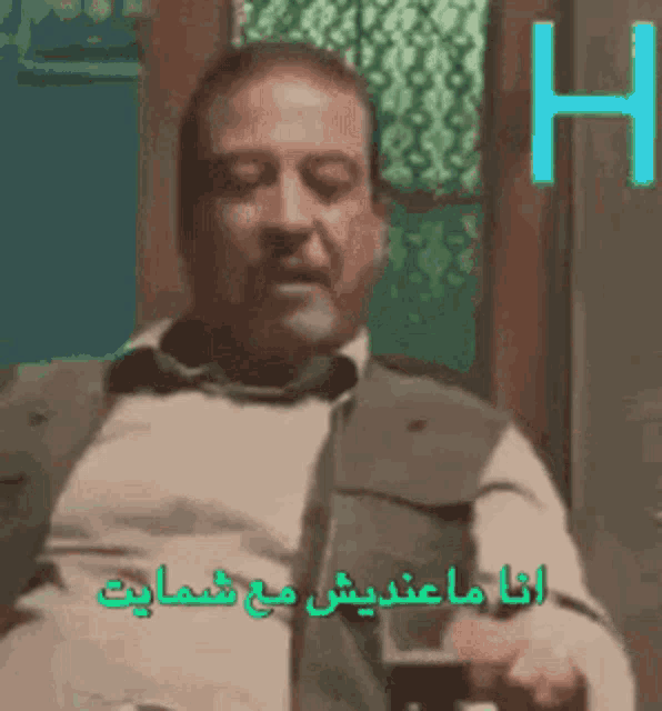a man is standing in front of a window with arabic writing on it .