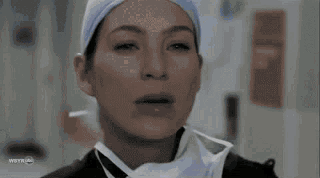 a man in a bullet proof vest is walking down a hospital hallway next to a nurse .