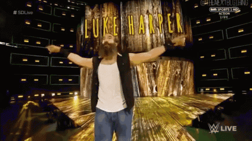 a wrestler named luke harper is standing in front of a wooden wall