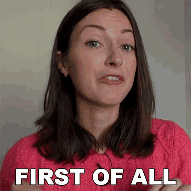a woman in a pink sweater is making a face and says first of all