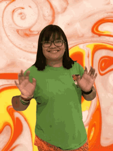 a girl wearing glasses and a green shirt that says ' s ' on it