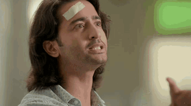 a man with a bandage on his forehead is looking up