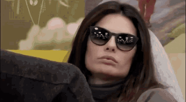 a woman is wearing sunglasses and a turtleneck