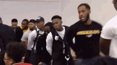 a group of young men are standing in a row in a room .