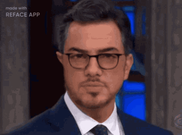 a man wearing glasses and a suit is being made with reface app