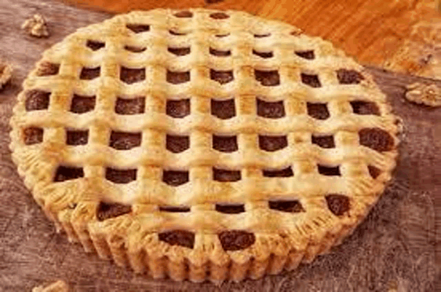 a pie with a lattice crust and walnuts on a wooden table .