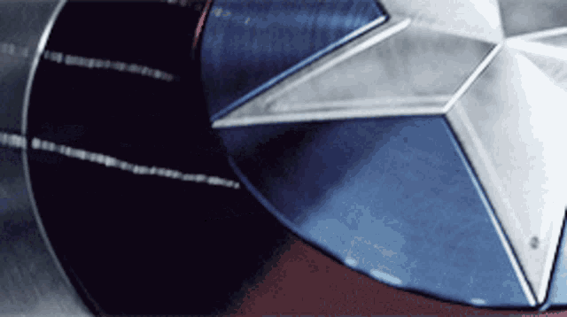 a close up of a captain america shield on a red surface