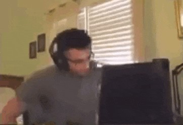 a man wearing headphones is looking at a laptop computer .