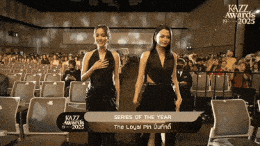 two women standing in front of a sign that says kazz awards