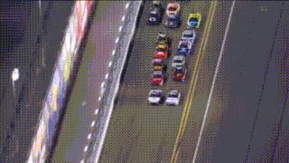 a bunch of cars are driving down a road and one has the number 8 on the side