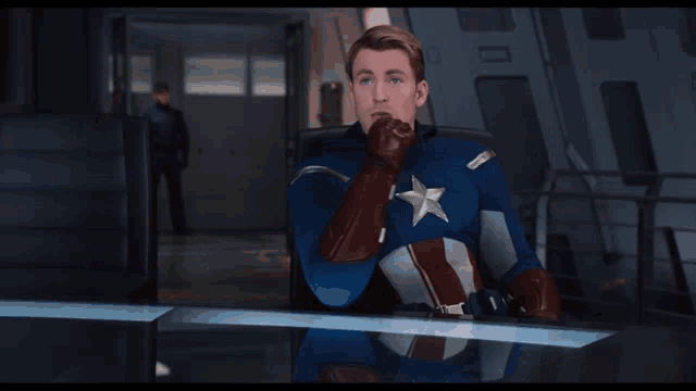 a man in a captain america costume is pointing