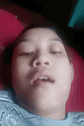 a girl laying on a bed with her eyes closed and a shirt that says ' n.w. ' on it