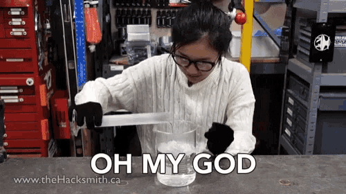 a woman in a white sweater holds a piece of metal in a beaker with the words oh my god written on the bottom