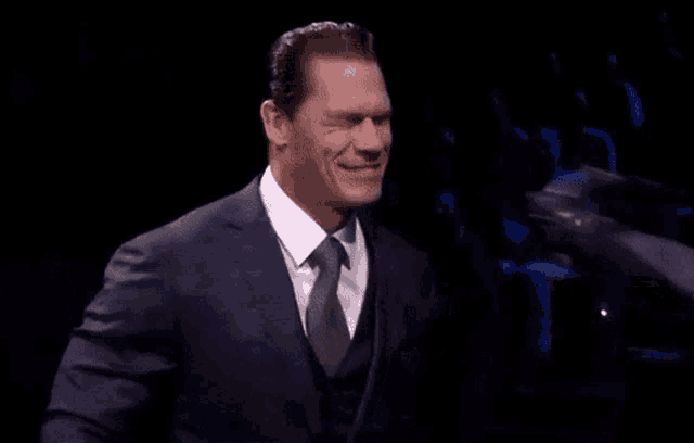 a man in a suit and tie is holding a black object
