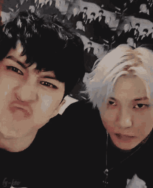two young men are making funny faces while holding hands