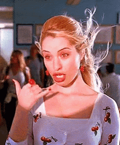 a woman in a cherry print dress is making a funny face