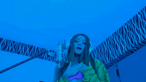 a woman singing into a microphone with the words clara-mente written below her